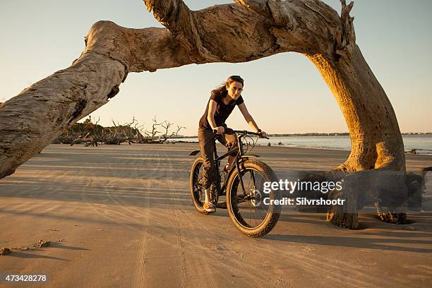 attractive woman in her 30's riding on the beach - jekyll island stockfoto's en -beelden