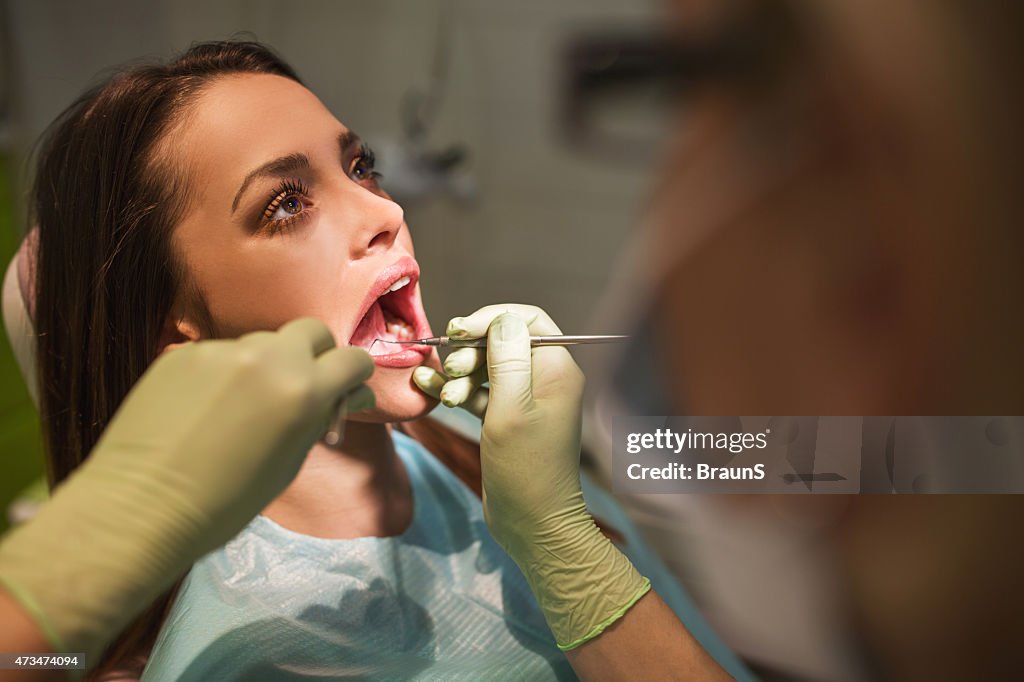 Woman having her teeth checked at dentist office.