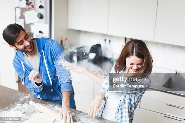 pareja joven cocinar juntos en casa. - haciendo burla fotografías e imágenes de stock