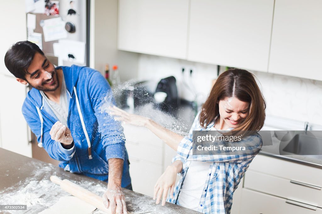 Young couple cooking together at home.