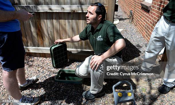 Marko Mackovic, center, owner of Highlands Landscaping inspects a broken sprinkler system as he talks about improvements to the yard of Denver Post...