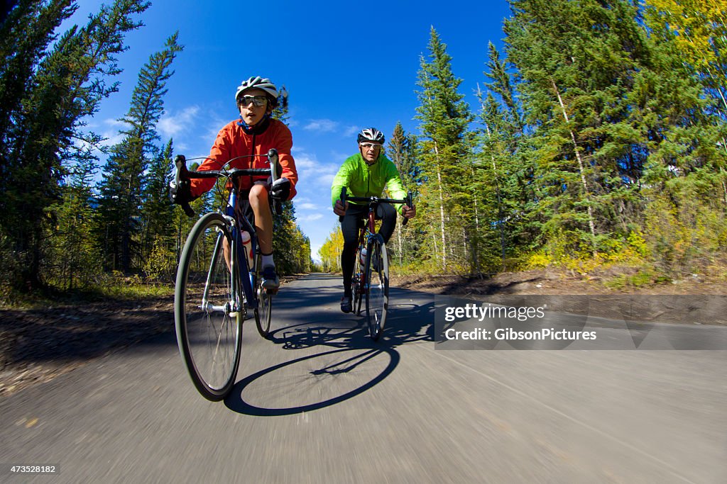 Father and son on bicycles road biking