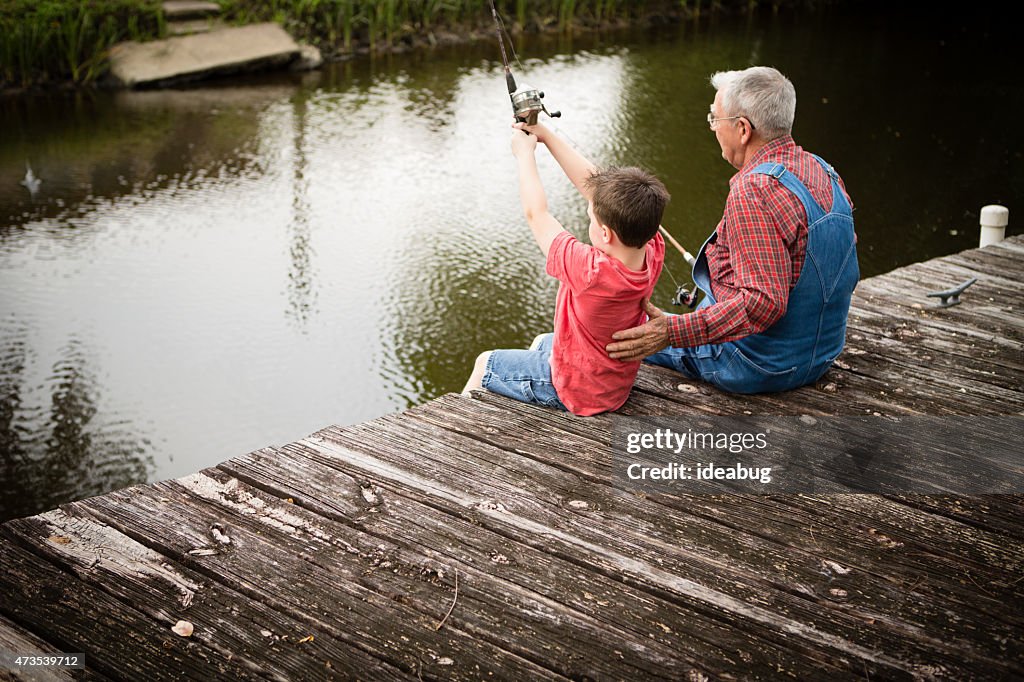 Happy Grandfather and Great Grandson Fishing on Dock