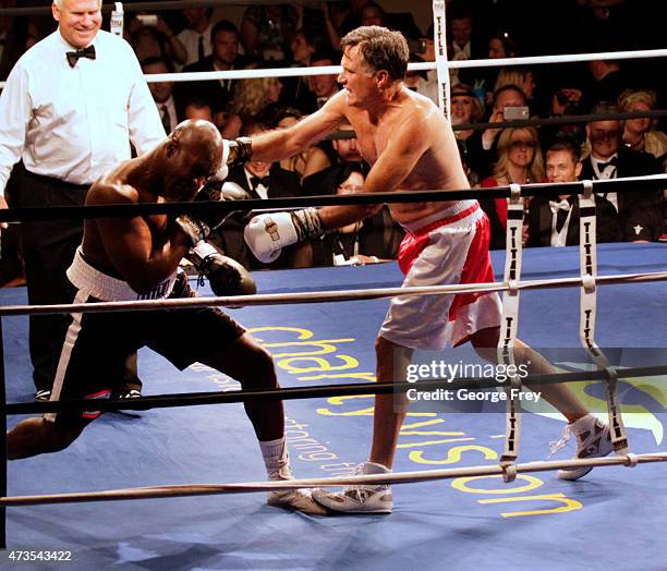 Mitt Romney, throws a punch and knocks down Evander Holyfield , during a fight in a charity boxing event on May 15, 2015 in Salt Lake City, Utah. The...