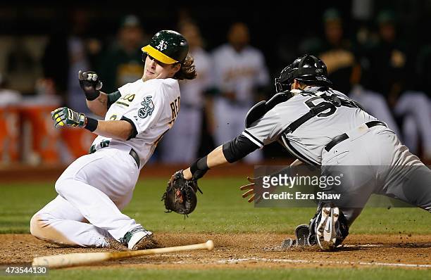 Josh Reddick of the Oakland Athletics slides safely past Geovany Soto of the Chicago White Sox to score on a hit by Billy Butler in the sixth inning...