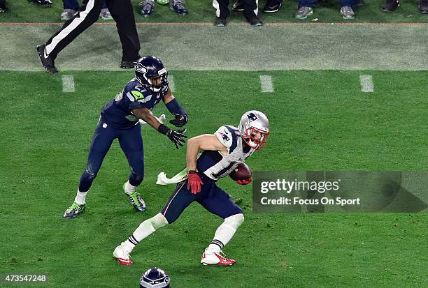 Julian Edelman of the New England Patriots breaks the tackle of Tharold Simon of the Seattle Seahawks in Super Bowl XLIX February 1, 2015 at the...