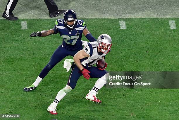 Julian Edelman of the New England Patriots breaks the tackle of Tharold Simon of the Seattle Seahawks in Super Bowl XLIX February 1, 2015 at the...