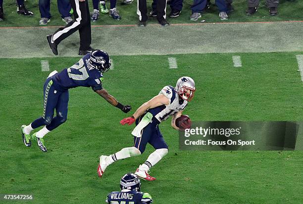 Julian Edelman of the New England Patriots breaks the tackle of Tharold Simon of the Seattle Seahawks in Super Bowl XLIX February 1, 2015 at the...