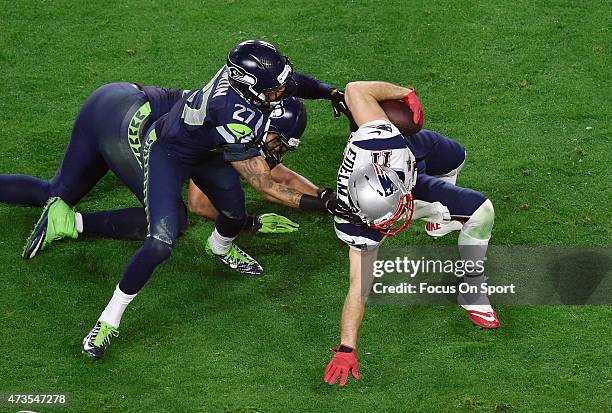 Julian Edelman of the New England Patriots gets tackled by Tharold Simon of the Seattle Seahawks in Super Bowl XLIX February 1, 2015 at the...