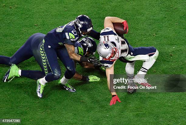 Julian Edelman of the New England Patriots gets tackled by Tharold Simon of the Seattle Seahawks in Super Bowl XLIX February 1, 2015 at the...