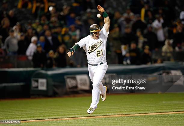 Stephen Vogt of the Oakland Athletics raises his arm as the ball goes over his head as he attempts to score the tying run in the ninth inning of...