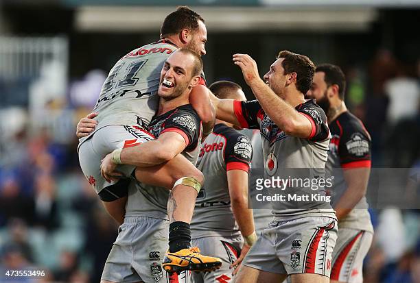 Bodene Thompson of the Warriors celebrates with Simon Mannering (R and team mates after scoring the winning try in golden point extra time during the...