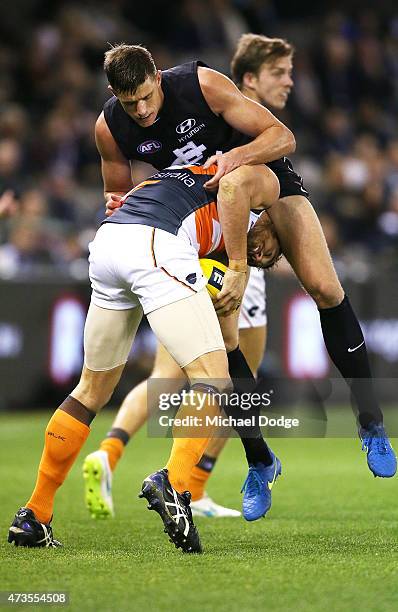 Shane Mumford of the Giants burrows under Cameron Wood of the Blues during the round seven AFL match between the Carlton Blues and the Greater...