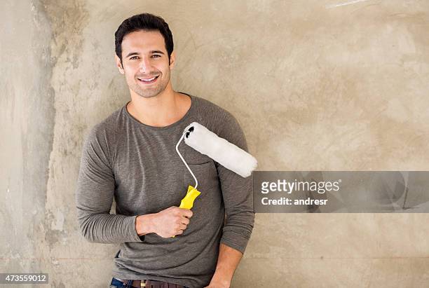 man painting a wall at home - holding paint roller stock pictures, royalty-free photos & images