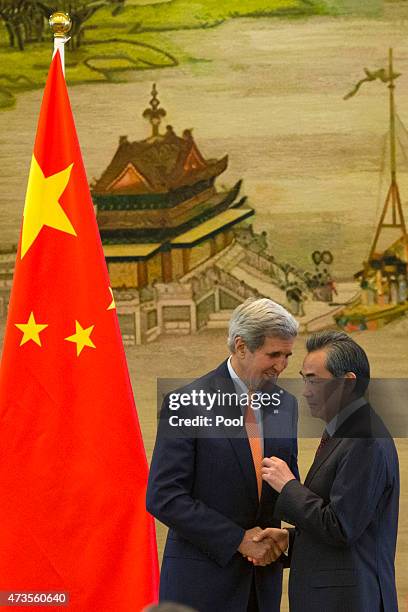 Secretary of State John Kerry and Chinese Foreign Minister Wang Yi shake hands after a press conference following meetings at the Ministry of Foreign...