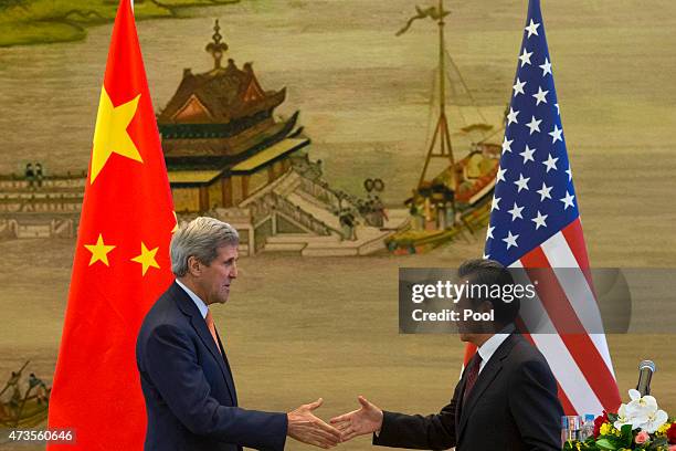 Secretary of State John Kerry and Chinese Foreign Minister Wang Yi shake hands after a press conference following meetings at the Ministry of Foreign...