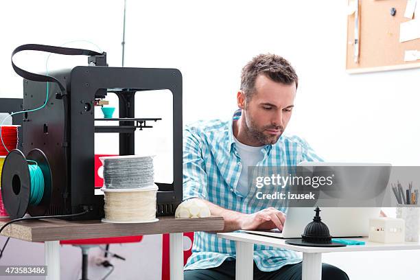 hombre en impresora 3d oficina usando computadora portátil - 3d printing fotografías e imágenes de stock