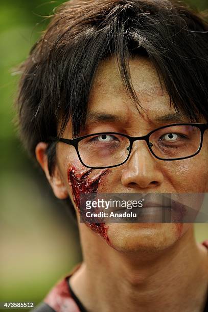 Participants take part in a 'zombie walk' at a park in Tokyo on May 16, 2015. More than 100 zombie fans lurched around a city park for an annual...