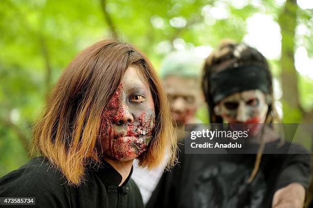 Participants take part in a 'zombie walk' at a park in Tokyo on May 16, 2015. More than 100 zombie fans lurched around a city park for an annual...