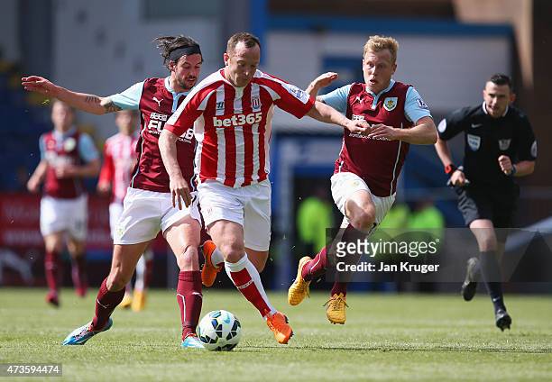 Charlie Adam of Stoke City competes against George Boyd and Scott Arfield of Burnley during the Barclays Premier League match between Burnley and...