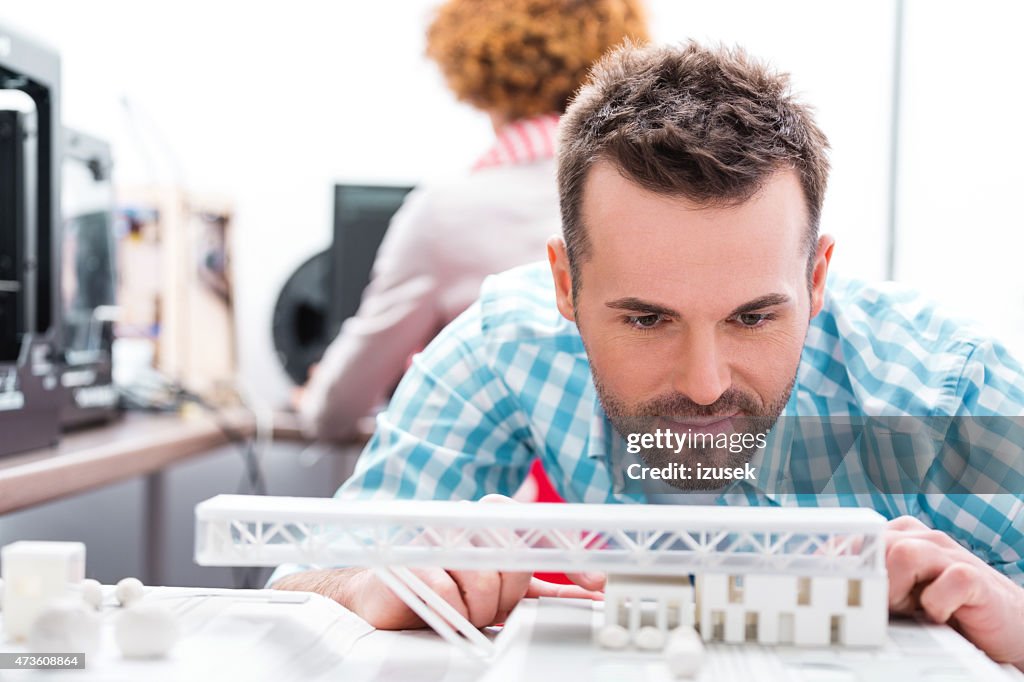 Man in 3D printer office watching printings