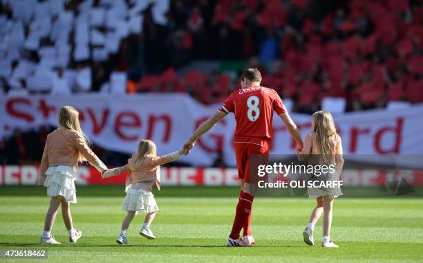 Liverpool's English midfielder Steven Gerrard walks onto the pitch with his daughters Lilly-Ella, Lourdes and Lexie at the start of the English...