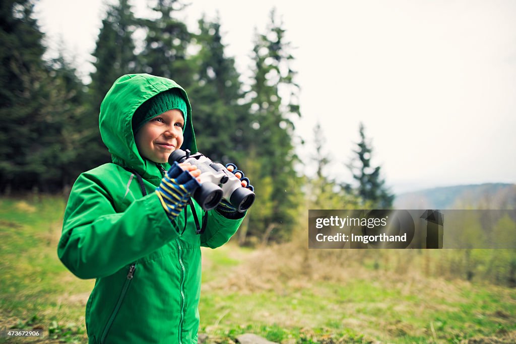 Little hiker looking with binoculars