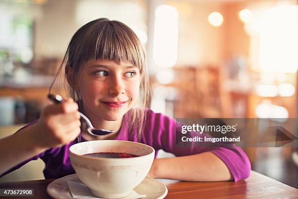 little girl eating beetroot soup - borscht stockfoto's en -beelden