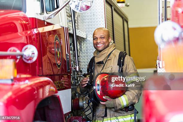 african american fire fighter standing next to truck - black firefighter stock pictures, royalty-free photos & images