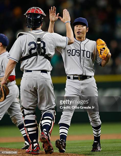 Closing pitcher Koji Uehara of the Boston Red Sox is congratulated by catcher Blake Swihart after defeating the Seattle Mariners 4-2 at Safeco Field...