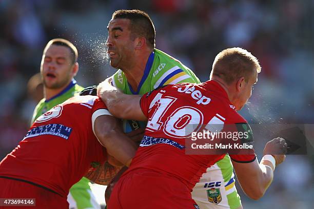 Paul Vaughan of the Raiders is tackled by Leeson Ah Mau and Mike Cooper of the Dragons during the round 10 NRL match between the St George Illawarra...