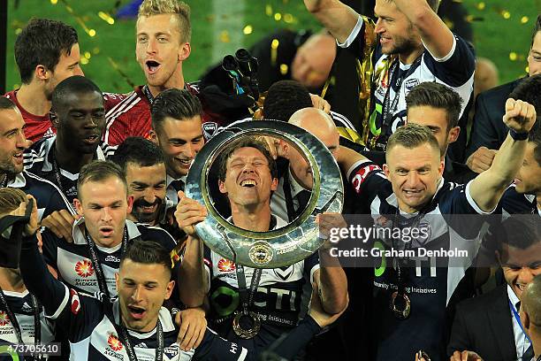 Mark Milligan of Melbourne Victory holds the trophy as he celebrates with his teamates following victory in the 2015 A-League Grand Final match...