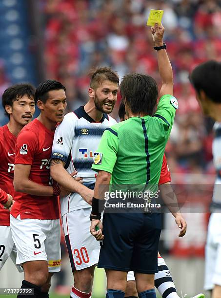 Michele Canini of FC Tokyo is shown a yellow card by referee Nobutsugu Murakami during the J.League match between Urawa Red Diamonds and FC Tokyo at...