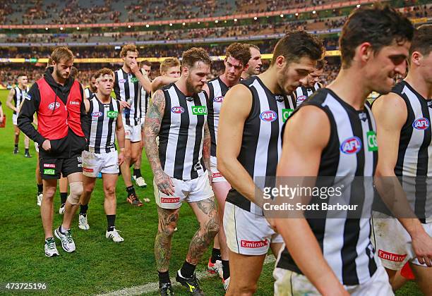 An injured Alan Toovey along with Dane Swan and Scott Pendlebury of the Magpies leave the field after losing the round seven AFL match between the...