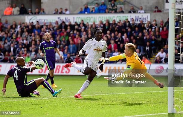 Goalkeeper Joe Hart of Manchester City saves the shot on goal from Bafetibis Gomis of Swansea City during the Barclays Premier League match between...