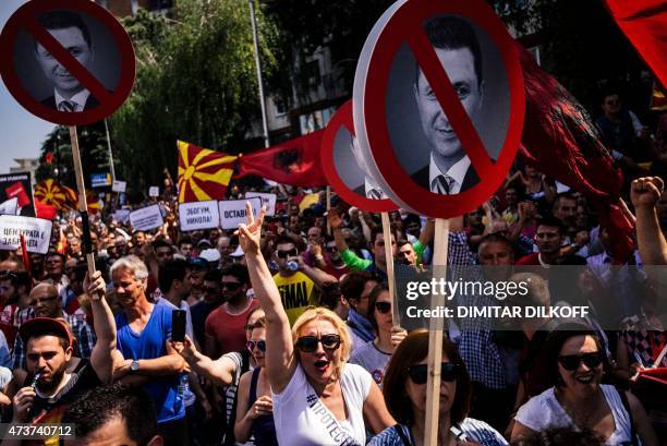 Peole hold placards with a picture of Macedonian Prime Minister Nikola Gruevski during an anti-government protest in downtown Skopje on May 17, 2015....