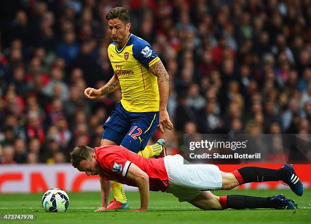 Phil Jones of Manchester United heads the ball clear of Olivier Giroud of Arsenal during the Barclays Premier League match between Manchester United...