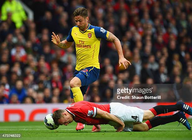Phil Jones of Manchester United heads the ball clear of Olivier Giroud of Arsenal during the Barclays Premier League match between Manchester United...