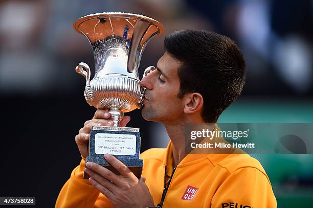 Novak Djokovic of Serbia kisses the Winner's Trophy after his victory over Roger Federer of Switzerland in the Men's Singles Final on Day Eight of...