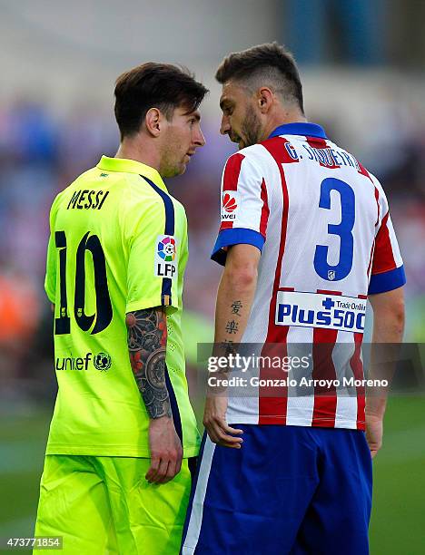 Lionel Messi of Barcelona and Guilherme Siqueira of Atletico Madrid clash during the La Liga match between Club Atletico de Madrid and FC Barcelona...