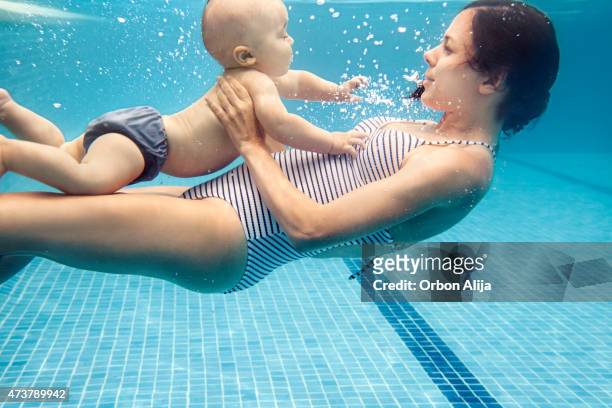mutter mit baby boy schwimmen - baby schwimmen stock-fotos und bilder