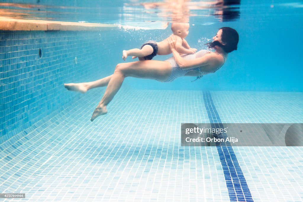 Mother swimming with baby boy