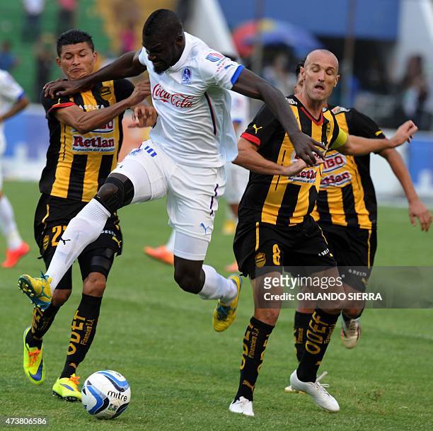 Colombian Javier Estupinan of Olimpia vies for the ball with Eder Delgado and Julio Rodriguez of Real Espana during their Honduran tournament...
