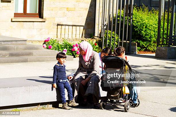 muslim woman with children eating pommes frites - chips essen stock pictures, royalty-free photos & images