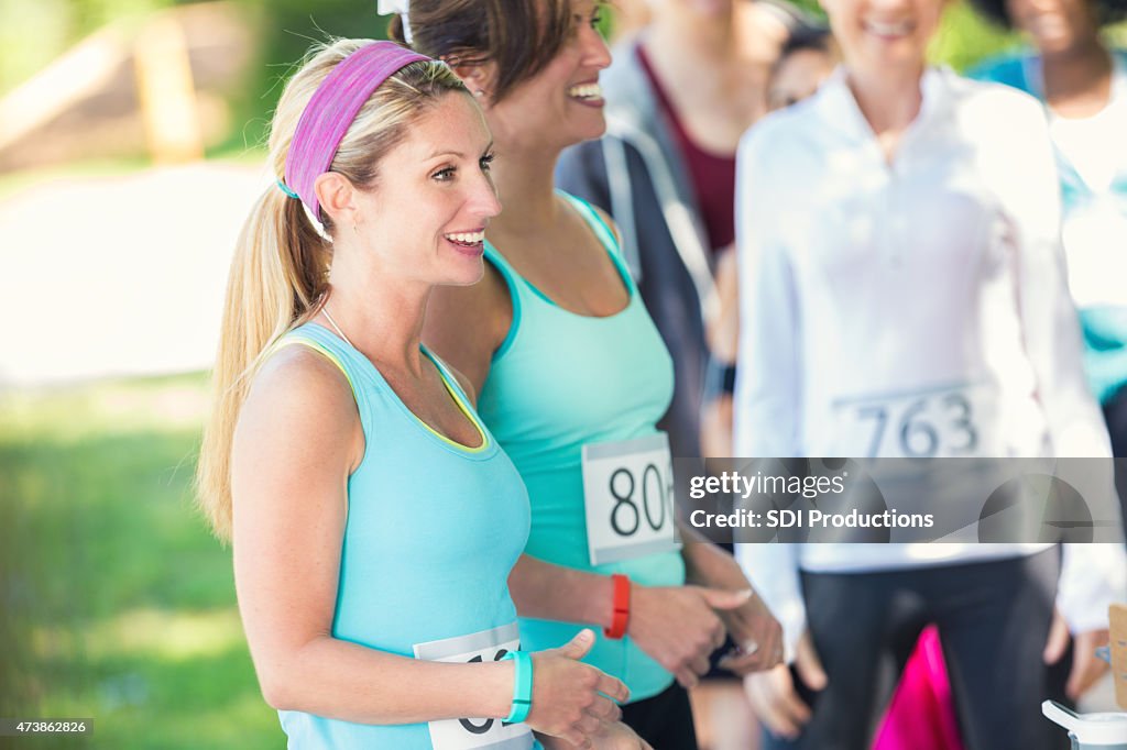 Woman standing with other runners after marathon or race