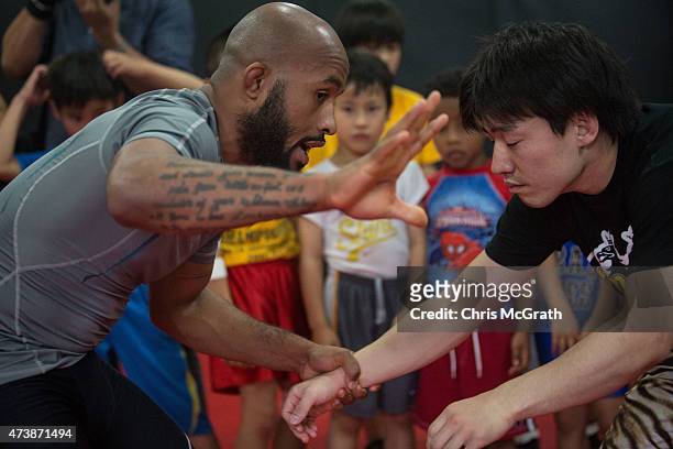 Current UFC Flyweight Champion Demetrious Johnson gives instructions to young wrestling students during a class at Krazy Bee Gym on May 18, 2015 in...