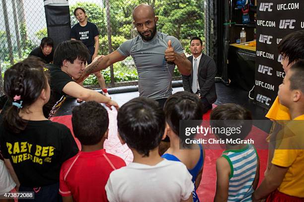 Current UFC Flyweight Champion Demetrious Johnson gives instructions to young wrestling students during a class at Krazy Bee Gym on May 18, 2015 in...