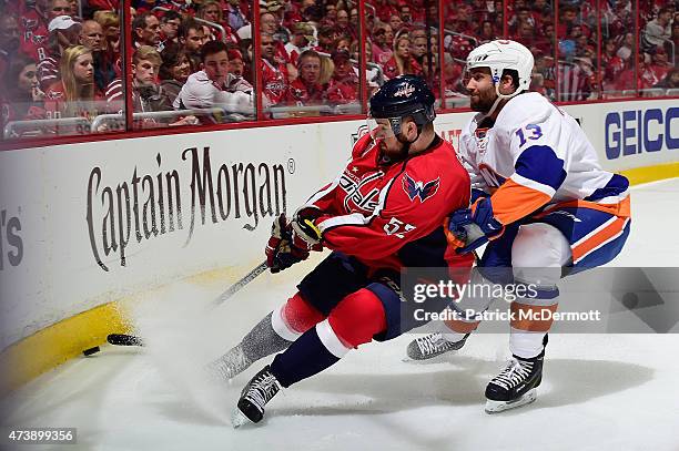 Mike Green of the Washington Capitals and Colin McDonald of the New York Islanders battle for the puck during the first period in Game Seven of the...