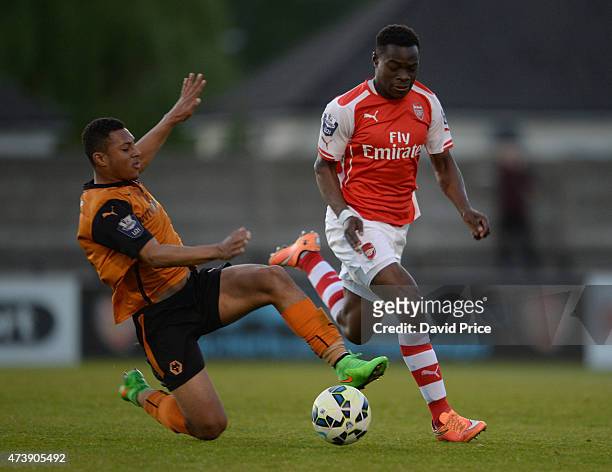 Marc Bola of Arsenal rides the challenge from Aaron Simpson of Wolves during the match between Arsenal U21s and Wolverhampton Wanderers U21s at...