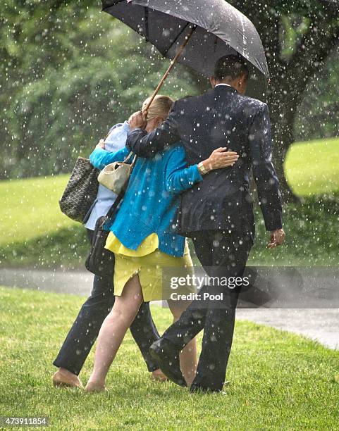 President Barack Obama, right, holds the umbrella for Valerie Jarrett, Senior Advisor to the President and Assistant to the President for Public...